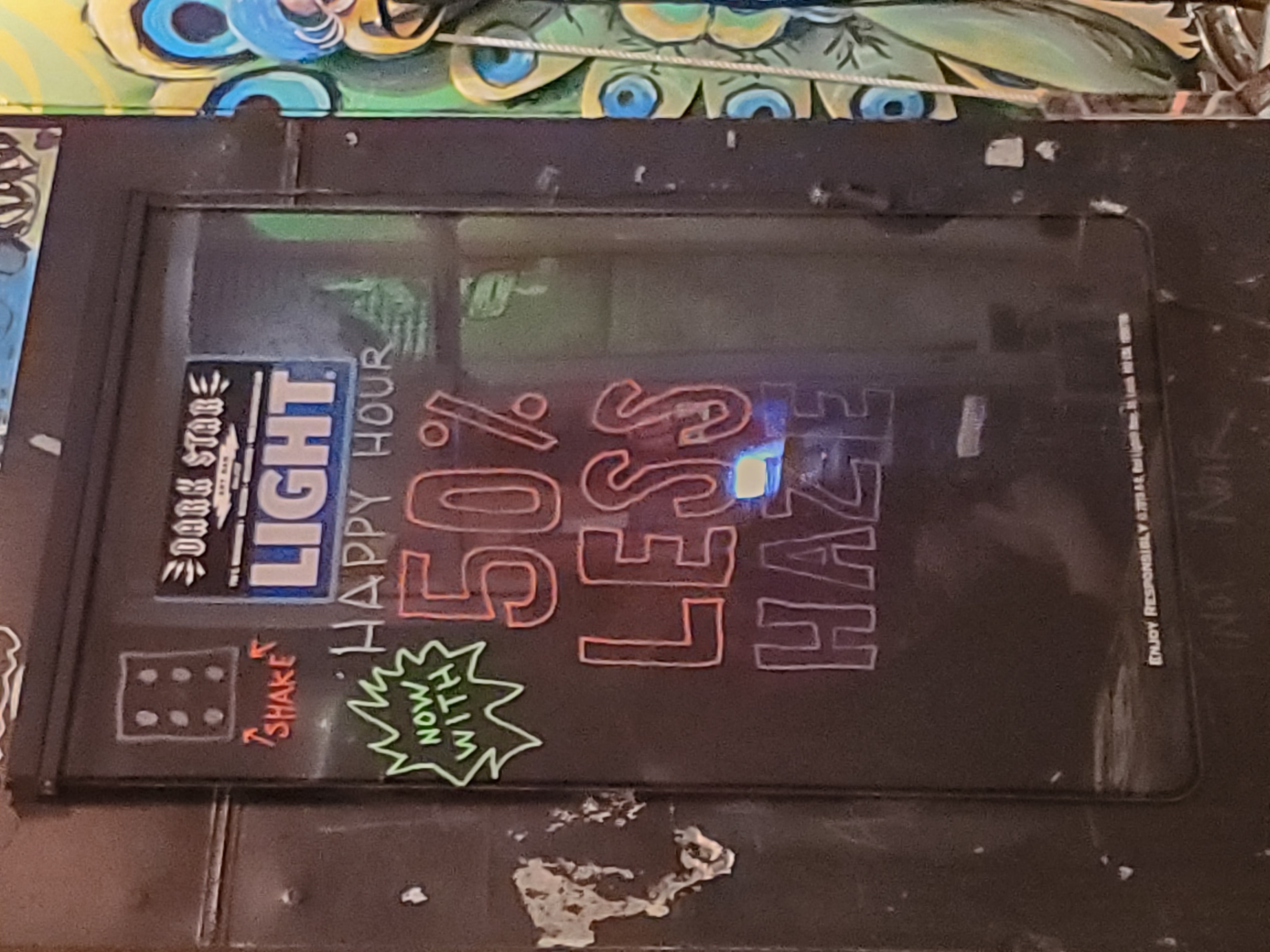 A hand-written bar sign reads "Happy Hour: Now with 50% Less Haze!"